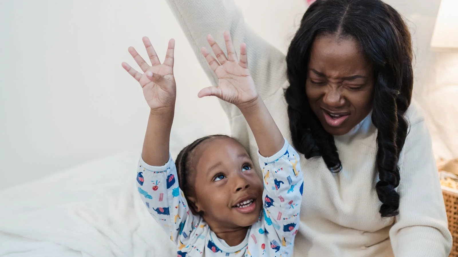 Mother reading with her child in a quiet bedroom.