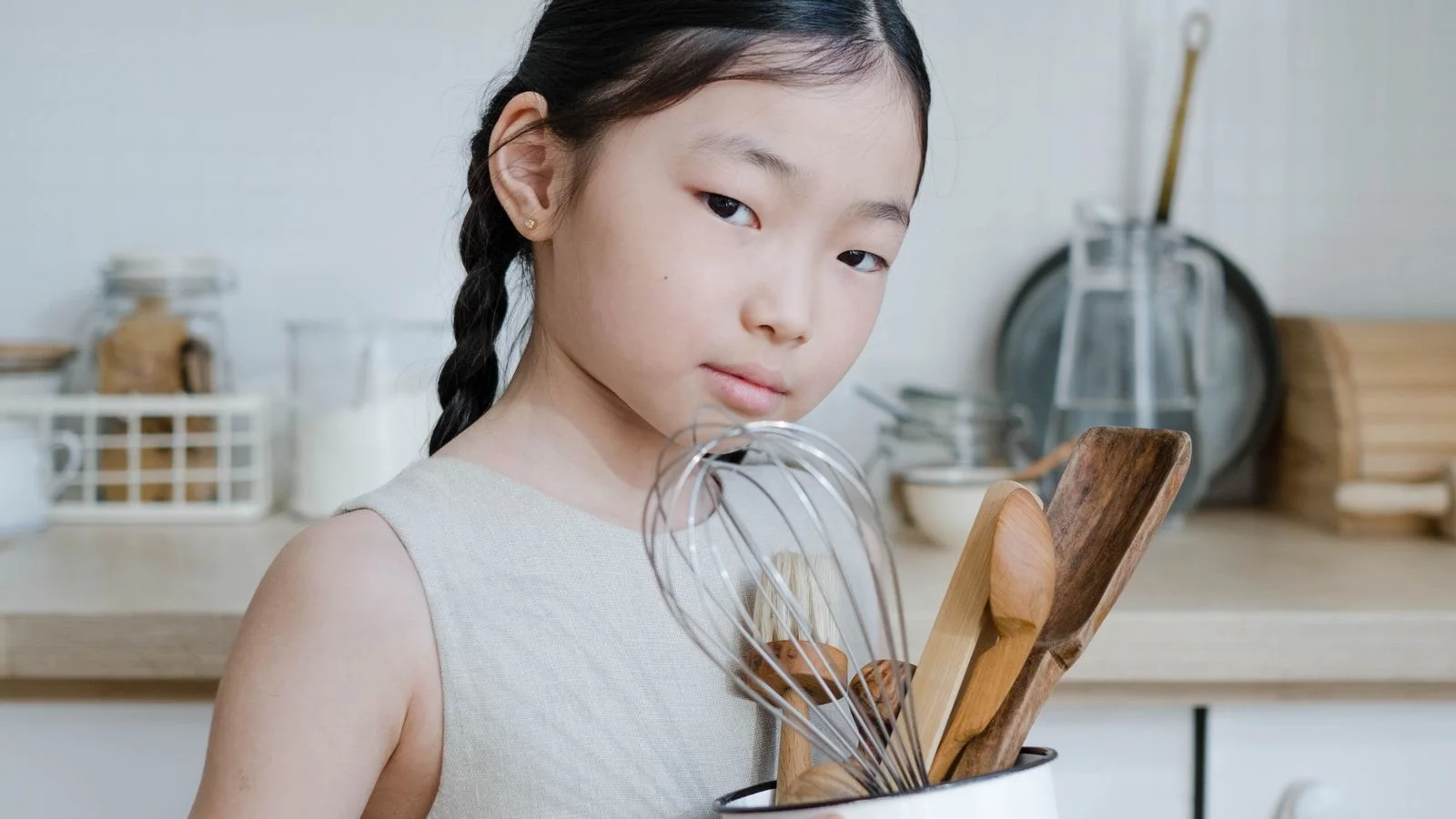 Child assists with kitchen utensils at home