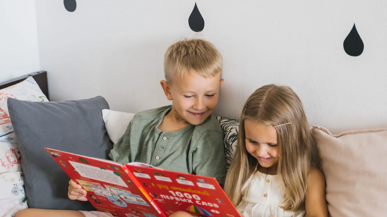 Children reading and choosing between activities together on a bed