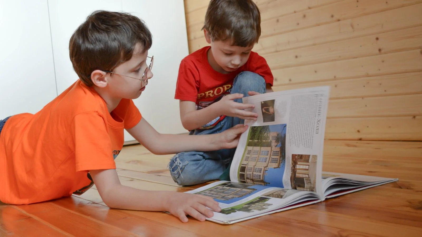 Two children quietly absorbed in reading at home