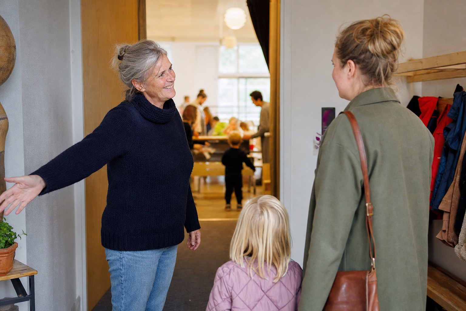 A volunteer welcomes a parent and child at the entrance of an association.